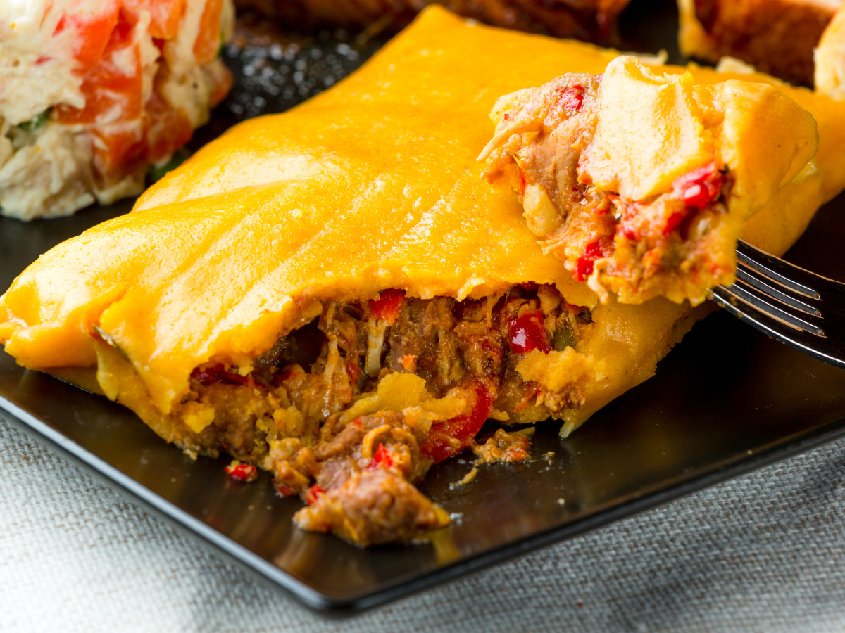 A close up of a piece of food on a plate with a fork
