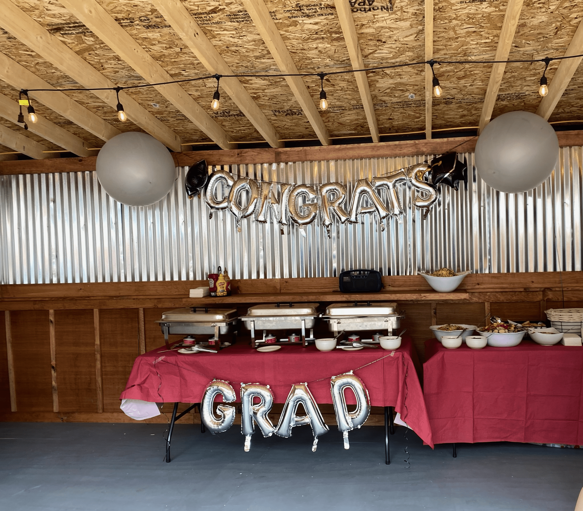 A room with a table and balloons that say congrats and grad at Happy Hour Bar & Grill