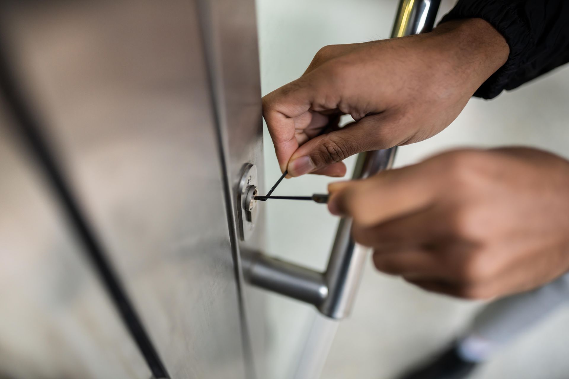 A person is using a screwdriver to open a door.