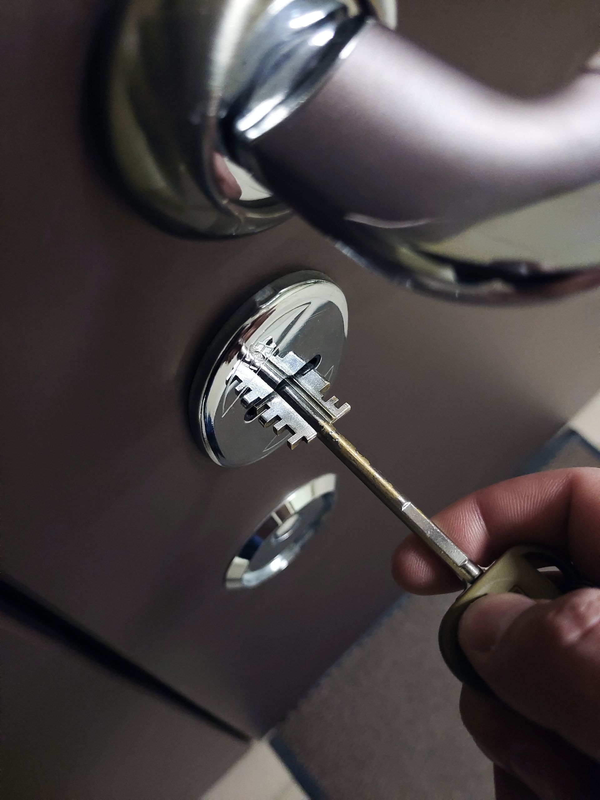 A person is holding a key in front of a door