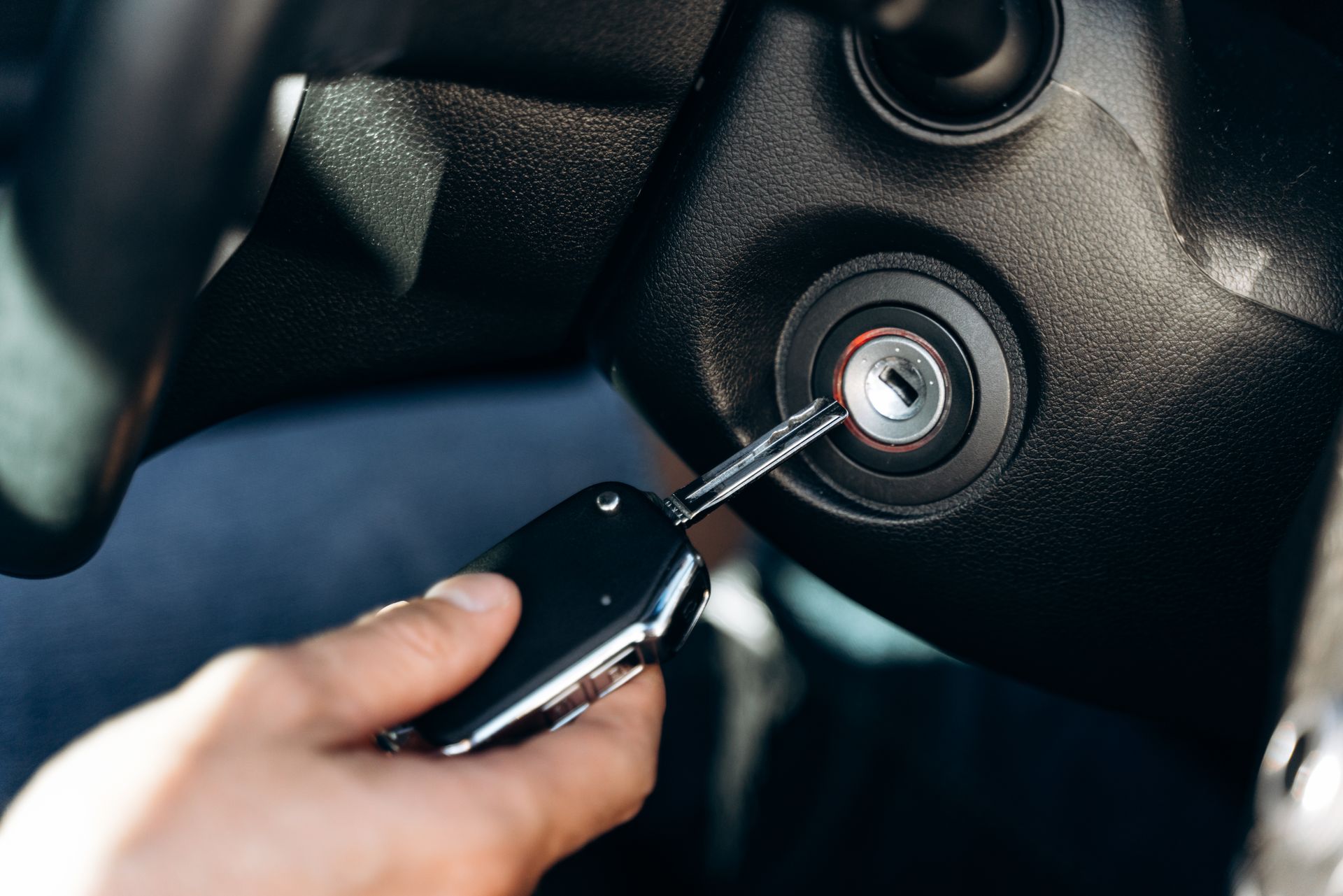 A person is using a car key to start a car.