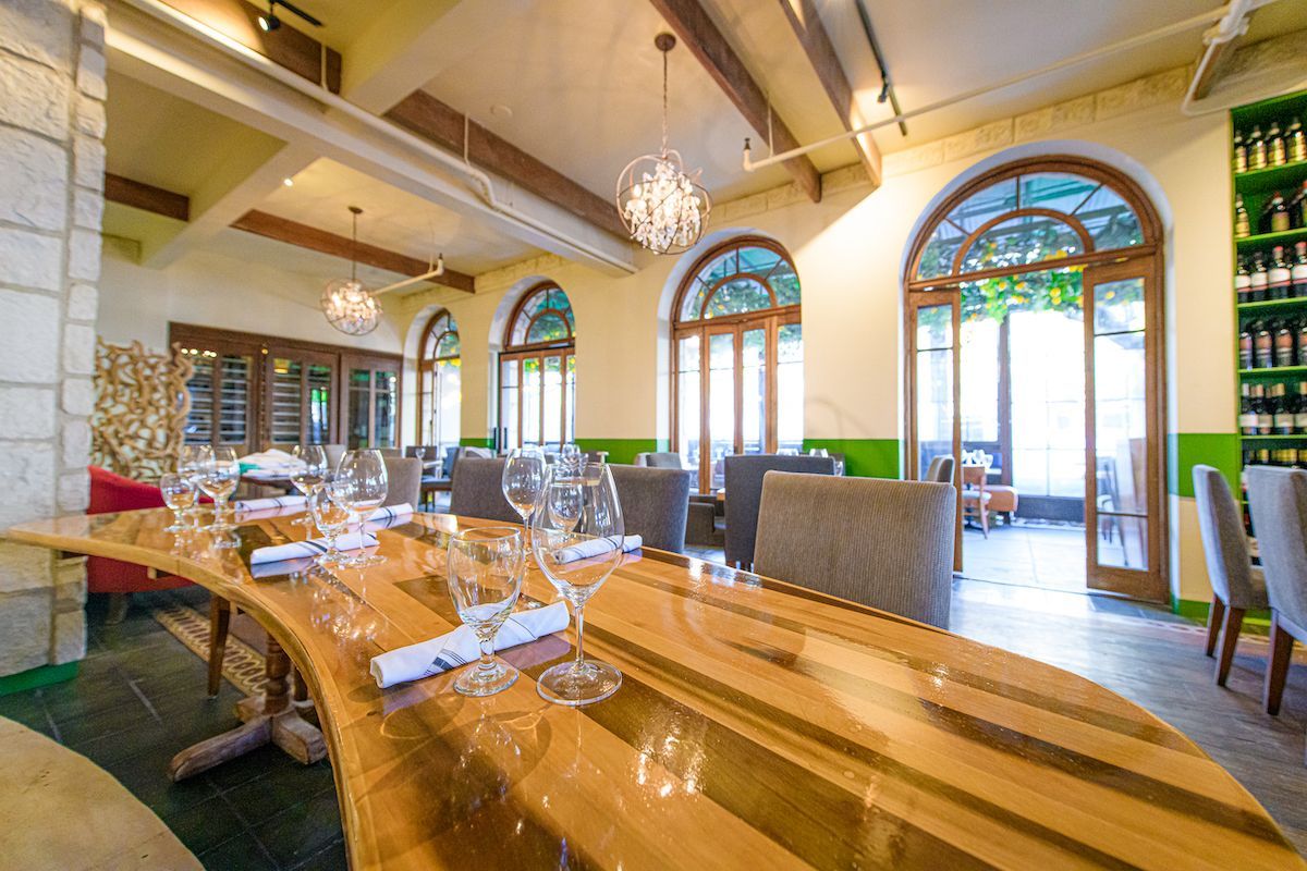 A restaurant with a wooden table and glasses on it.