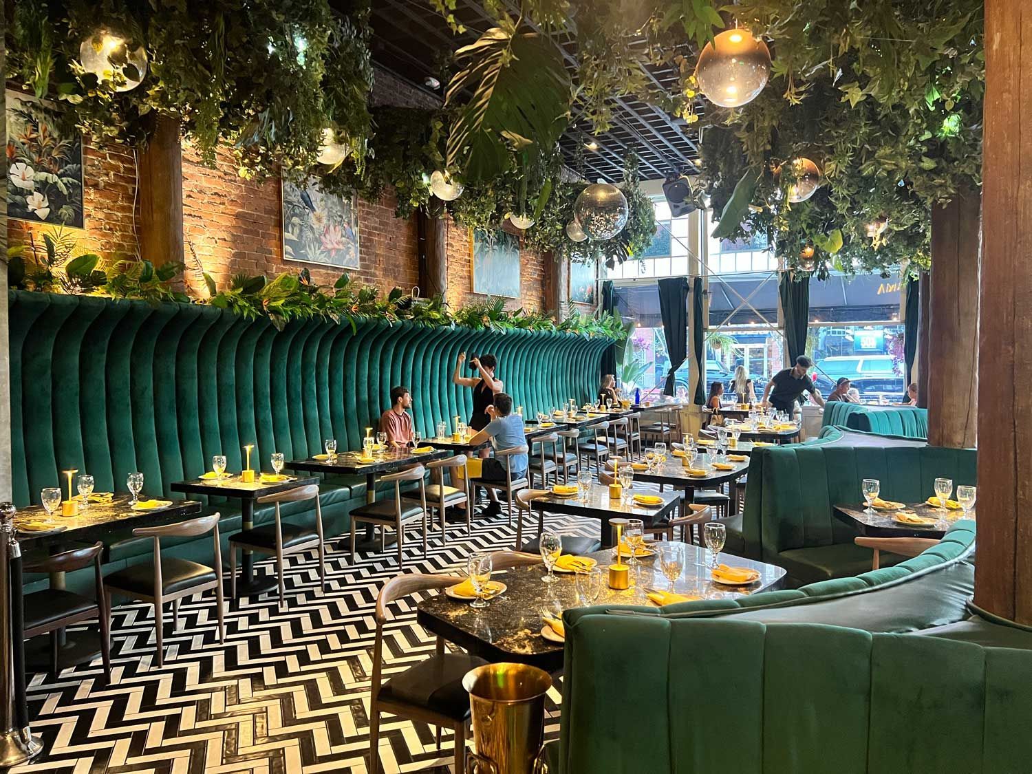 A restaurant with tables and chairs and a black and white chevron floor.