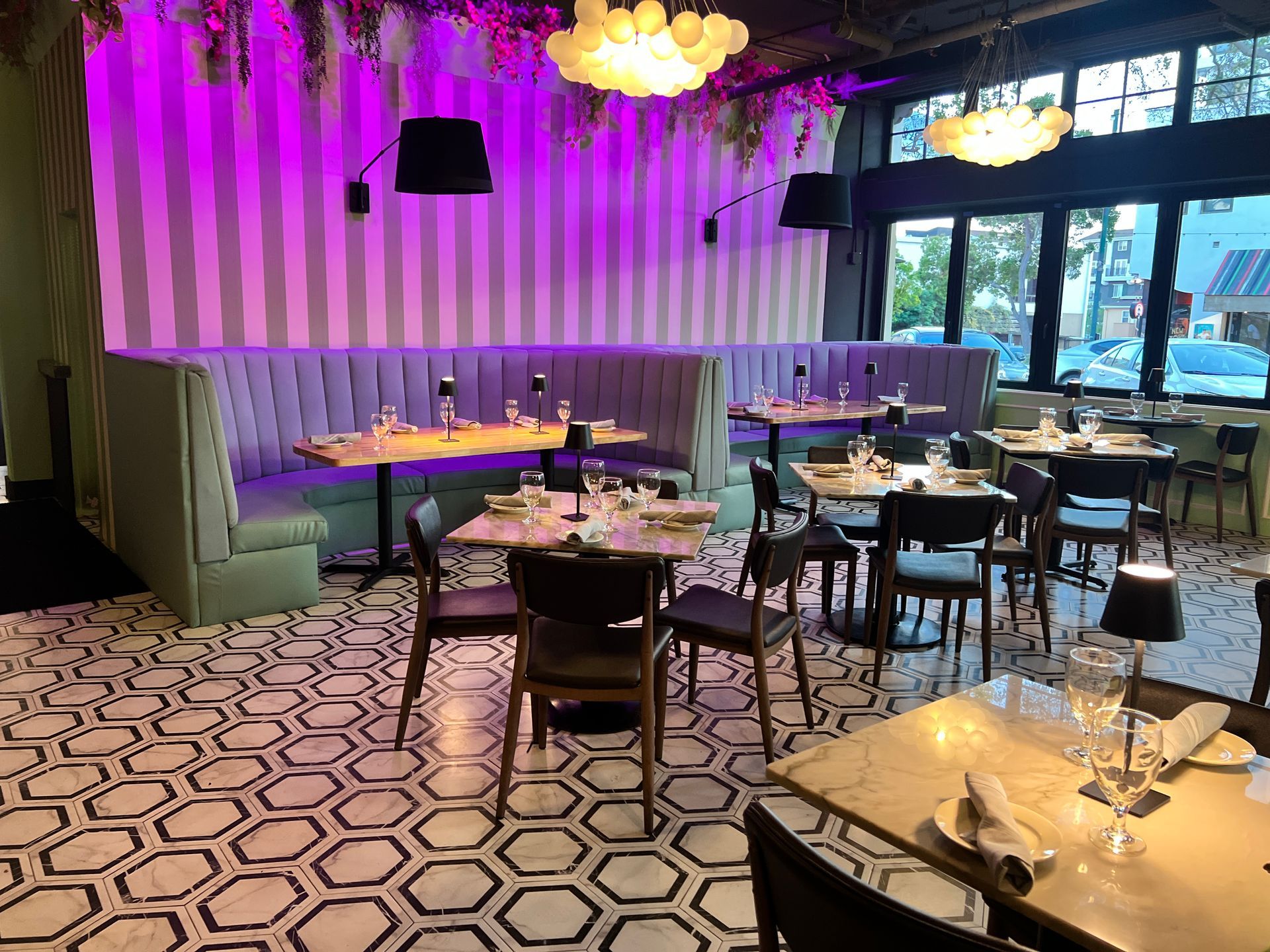 A restaurant with tables and chairs and a purple wall.