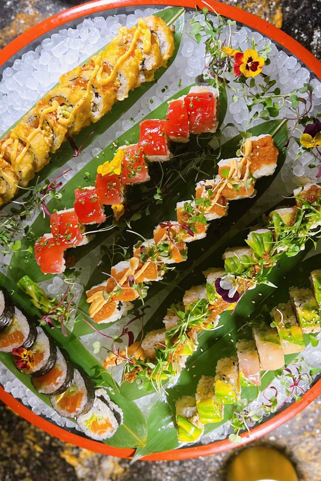 There are many different types of sushi on a plate.