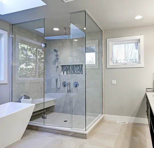A bathroom with a frameless walk in shower and a bathtub