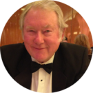 A man in a tuxedo and bow tie is sitting in a circle.