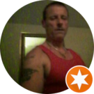 A man in a red tank top is standing in a circle with an orange star.