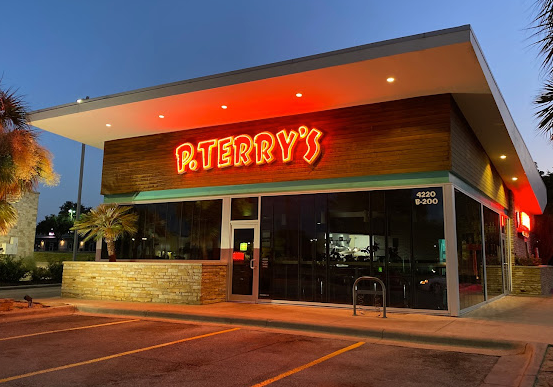 A restaurant called terry 's is lit up at night.