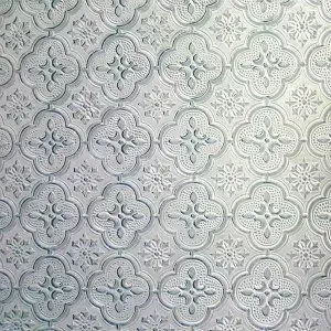 A close up of a white tile with a floral pattern on it.