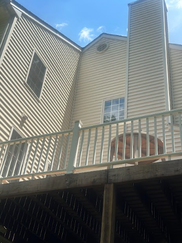 A house with a balcony and a chimney on the side of it.