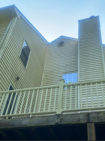 The back of a house with a balcony and a chimney