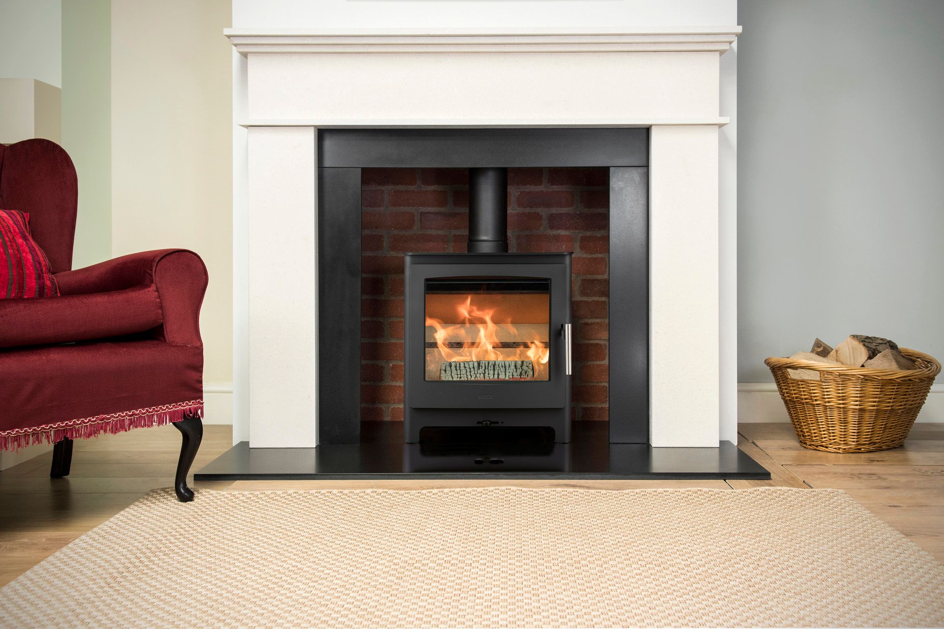 Heta Ambition 5 wood burning stove in a red brick fire chamber with stone surround, granite hearth and slips