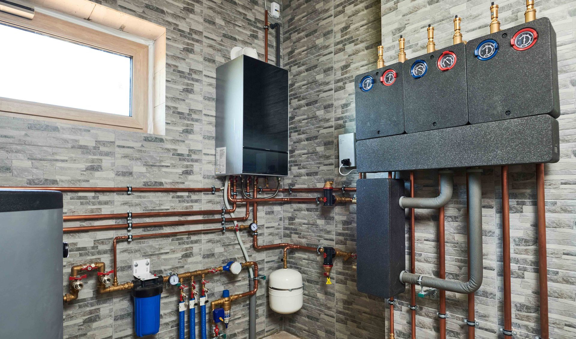 A boiler room with heating system components, copper pipes, and a window against a stone-like wall. A boiler room with heating system components, copper pipes, and a window against a stone-like wall.