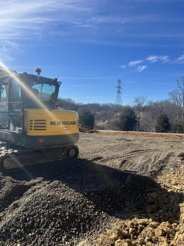Yellow New Holland excavator on a construction site; blue sky with sun.