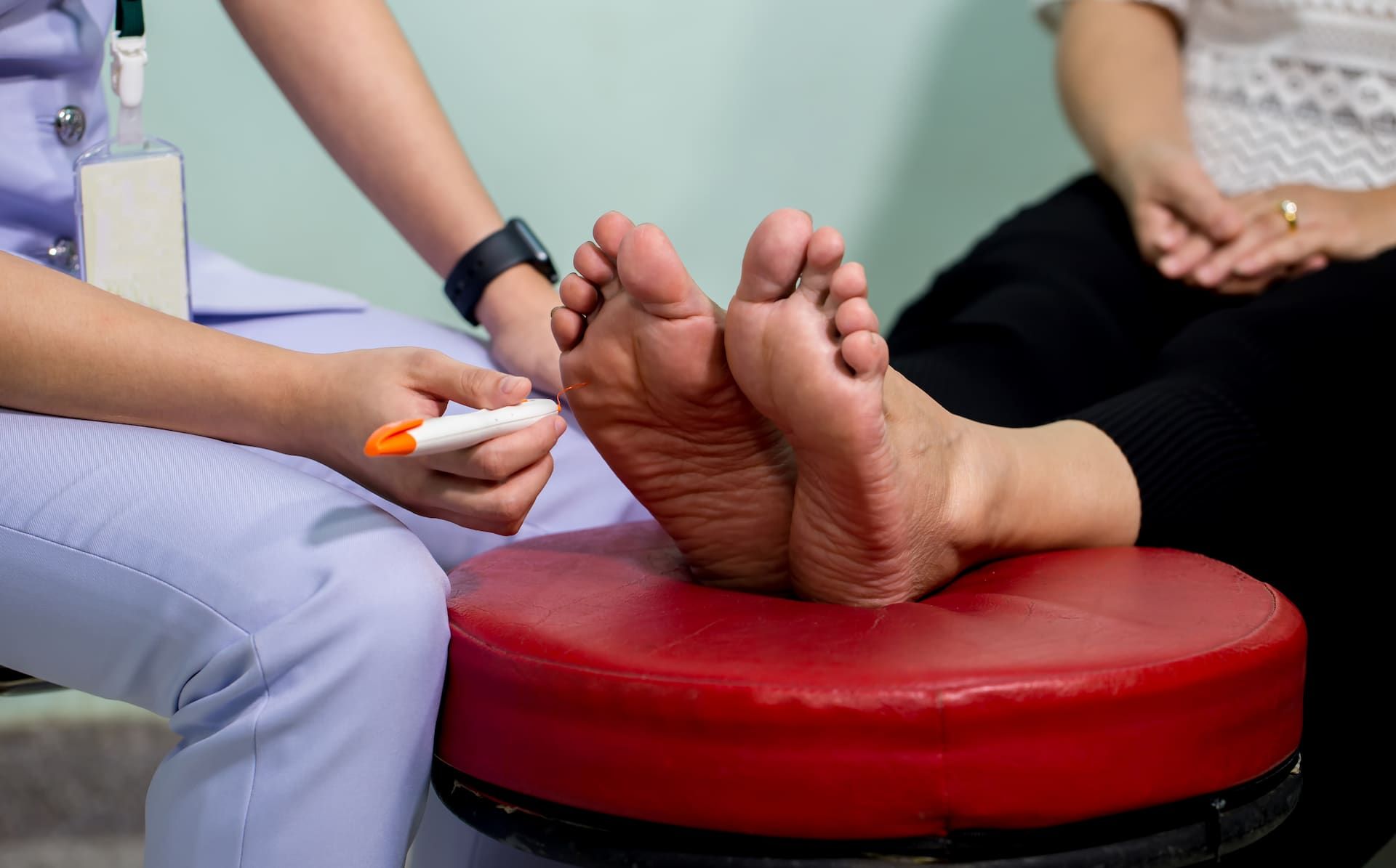A Nurse Is Writing On A Patient's Foot With A Marker — Hastings Podiatry Centre In Port Macquarie, NSW