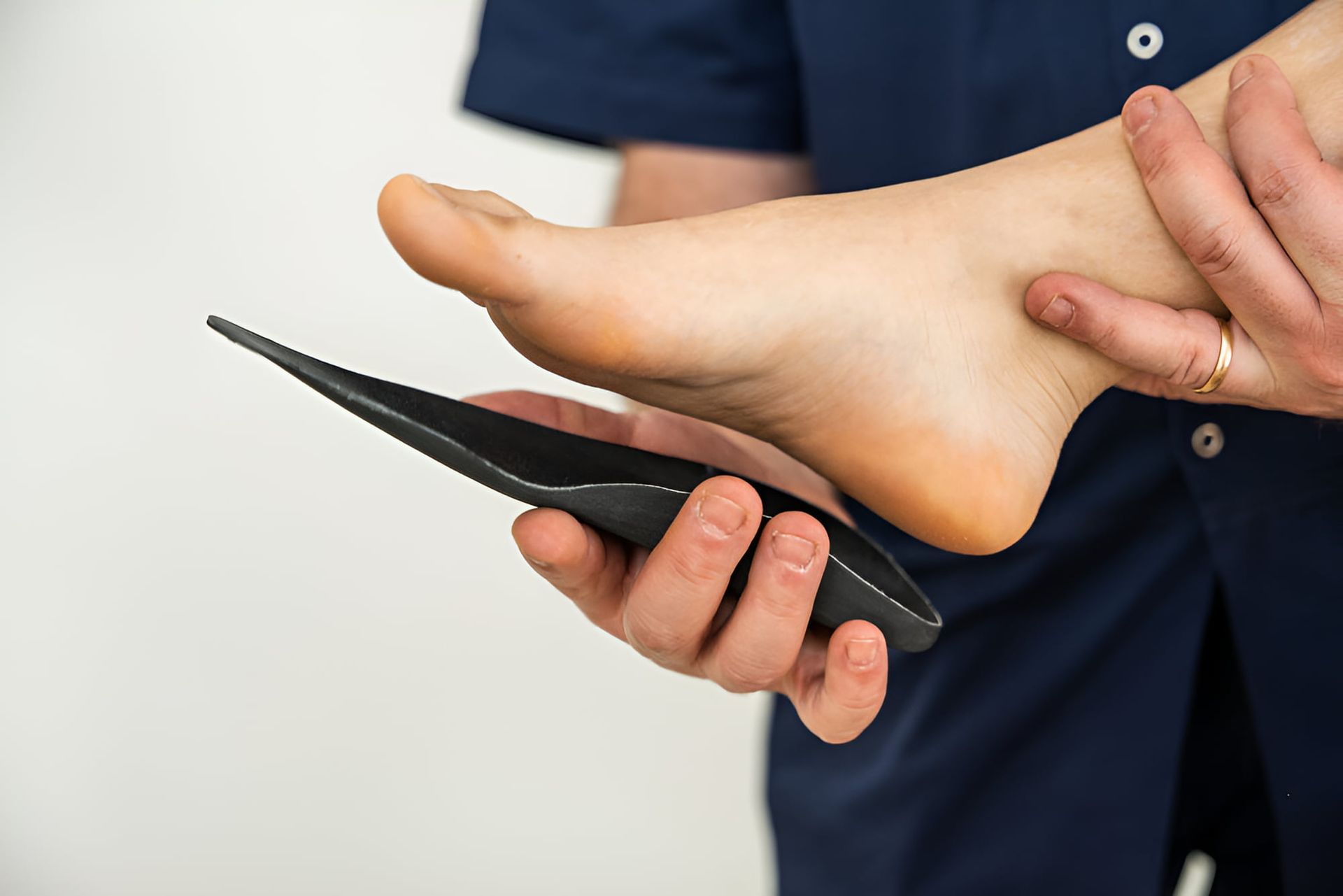 A Person Is Holding A Pair Of Insoles On Their Foot — Hastings Podiatry Centre In Port Macquarie, NSW