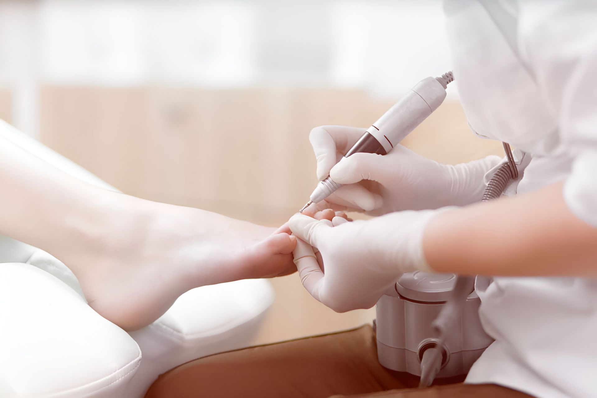 A Woman Is Getting Her Nails Done By A Nail Technician — Hastings Podiatry Centre In Port Macquarie, NSW