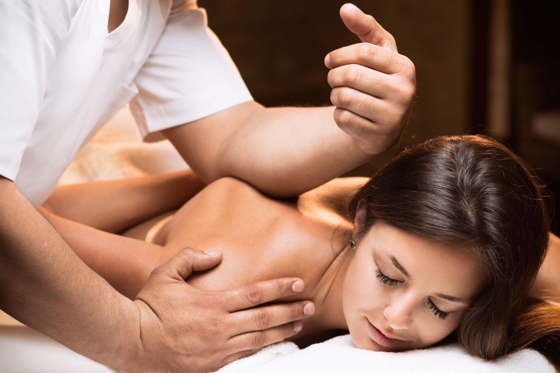 a woman is laying on a bed getting a massage from a man