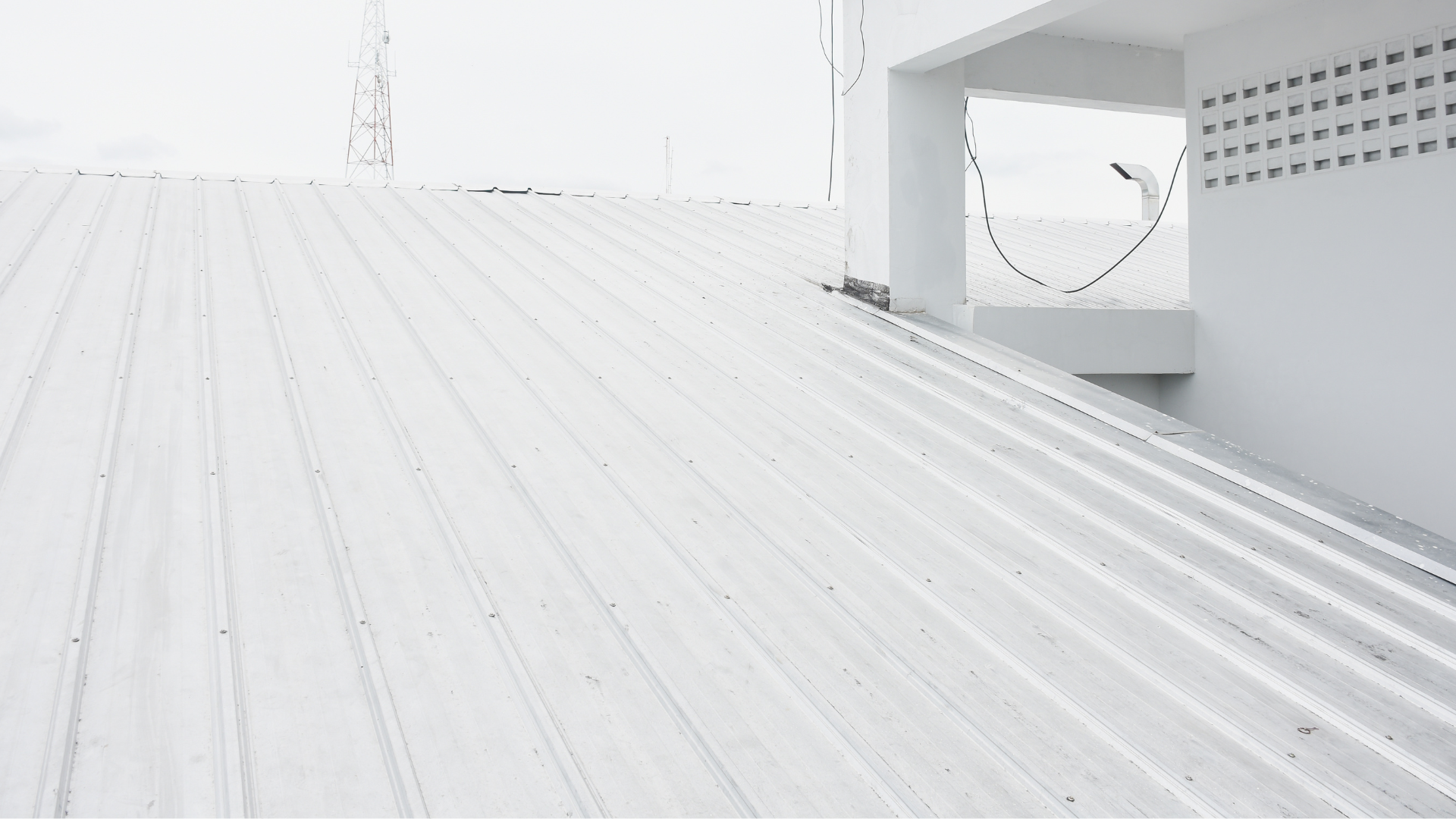 A white roof of a building with a window in the background.
