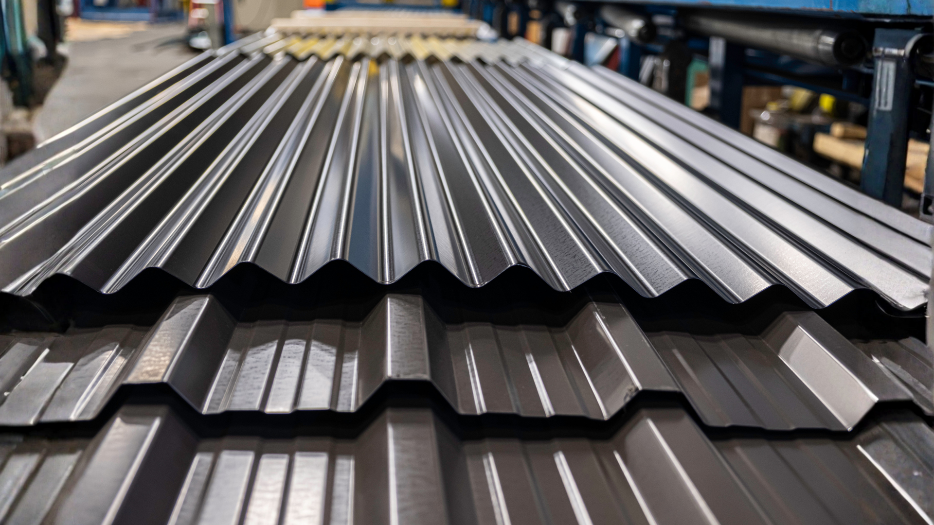 Stacked grey Colorbond roofing sheets ready for installation.