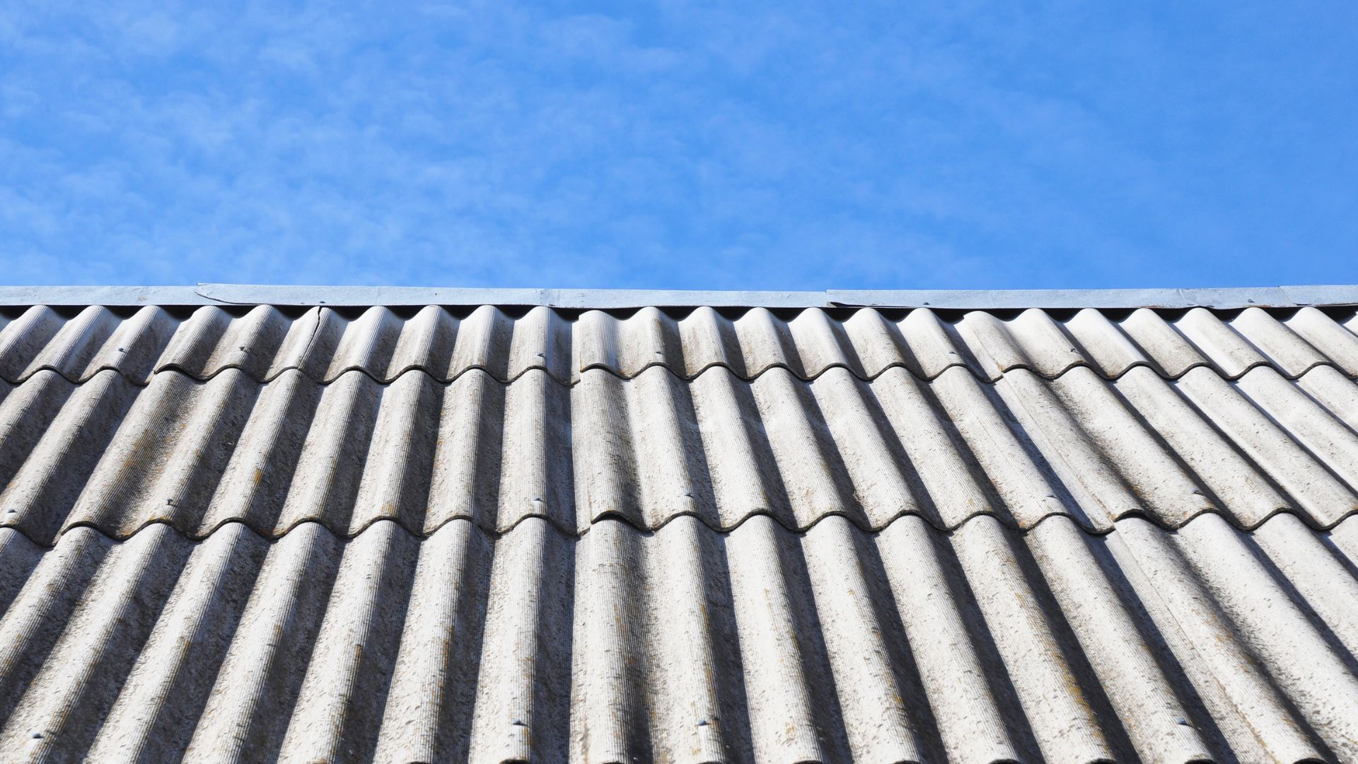 Weathered corrugated fibre cement roof sheets (often called asbestos roofing on older homes).