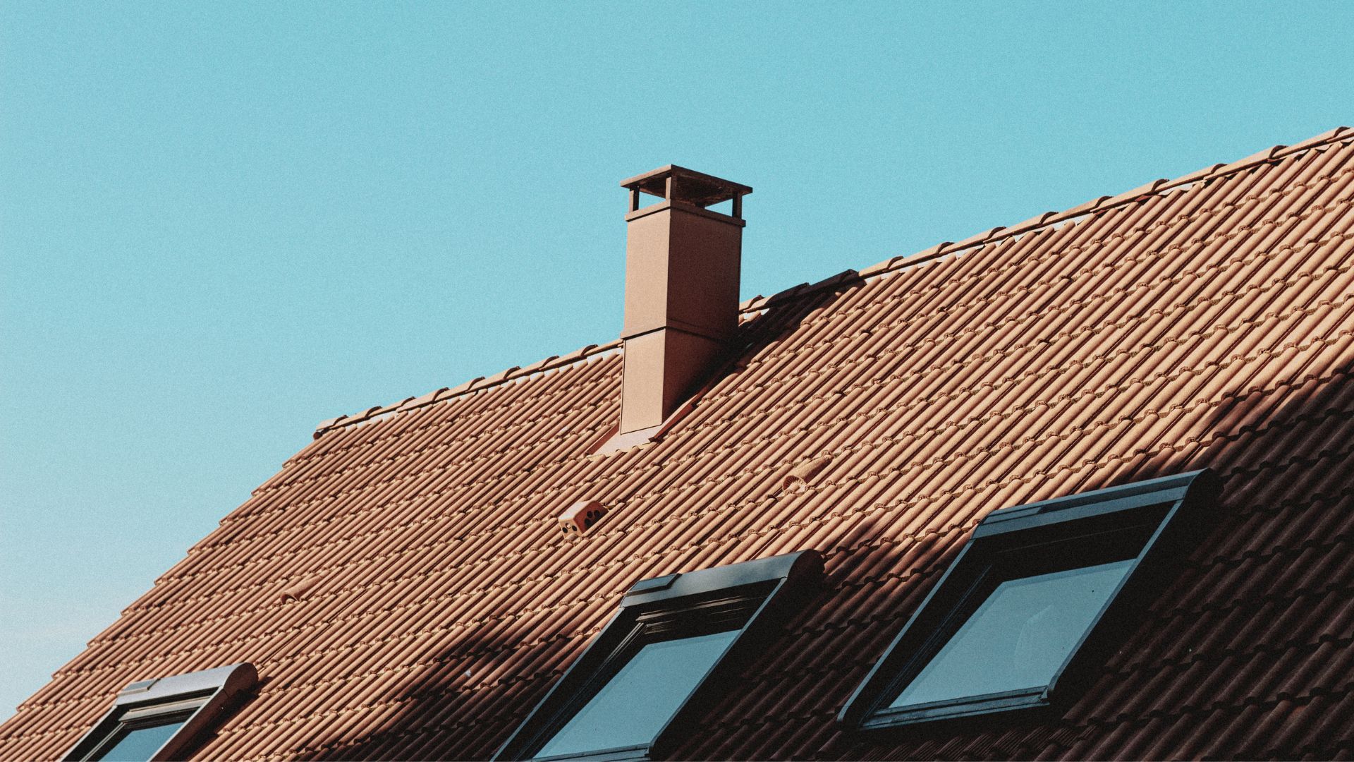 Terracotta tiled roof with skylights, showing energy-efficient roofing material and colour considerations.