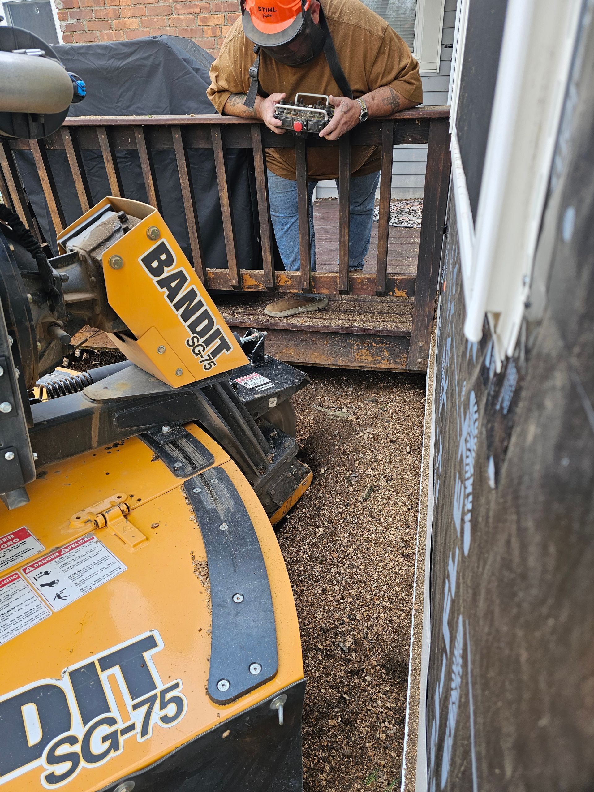 Worker using a yellow BANOI SG-75 machine to clear gravel beside a building stairway