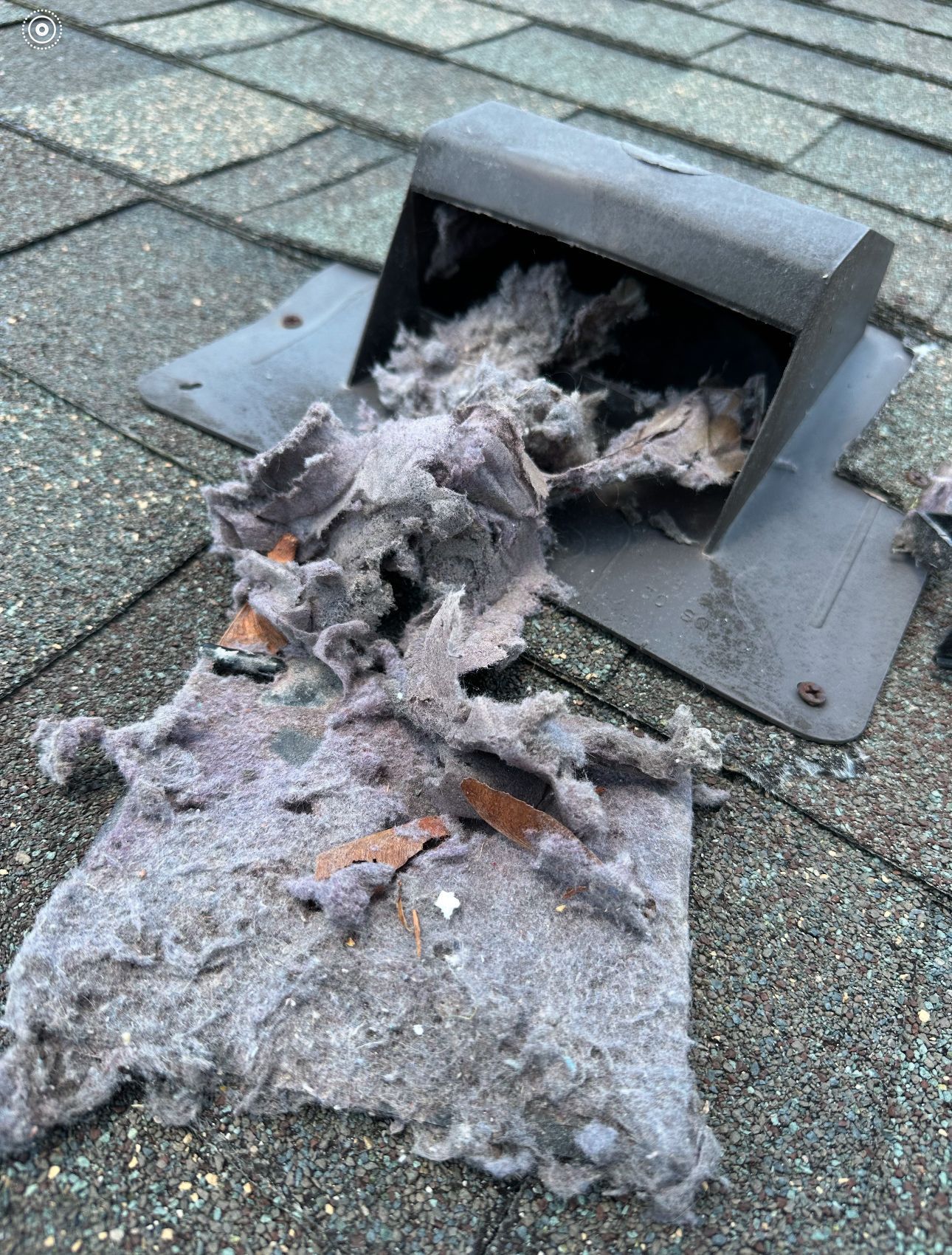 A roof HVAC vent with a lot of dust & debris coming out of it.