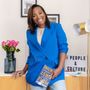A woman in a blue jacket is holding a book titled people first culture