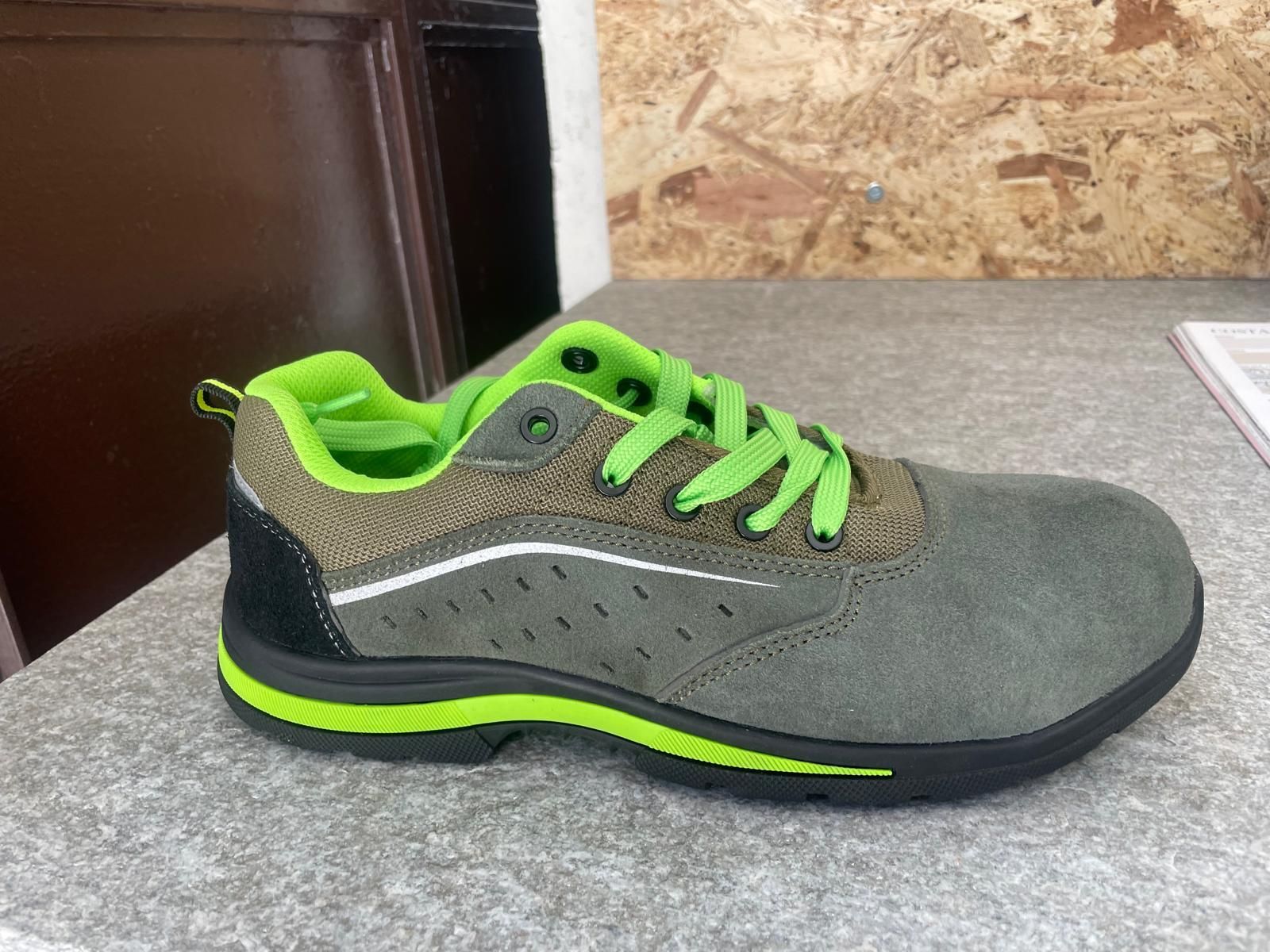 Scarpa sportiva grigia e verde neon su un tavolo, vista laterale