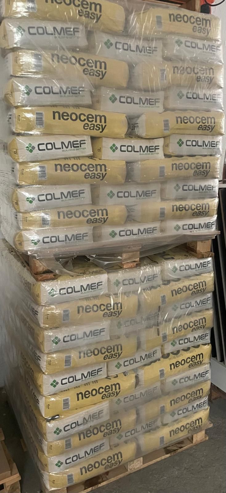 Pallet impilati di merci imballate in scatole e avvolte nella plastica in un magazzino o in un'area di stoccaggio.