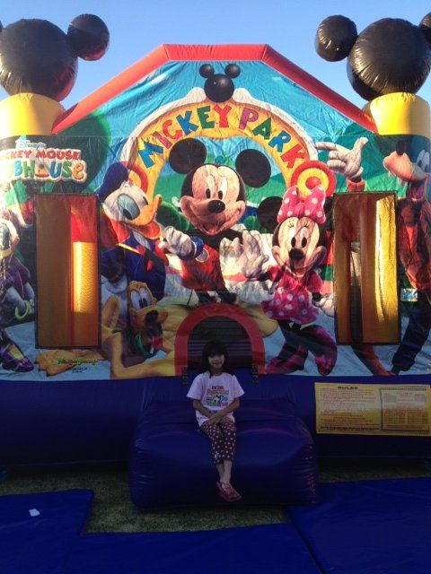 Young girl sits on an inflatable blue couch in front of a 