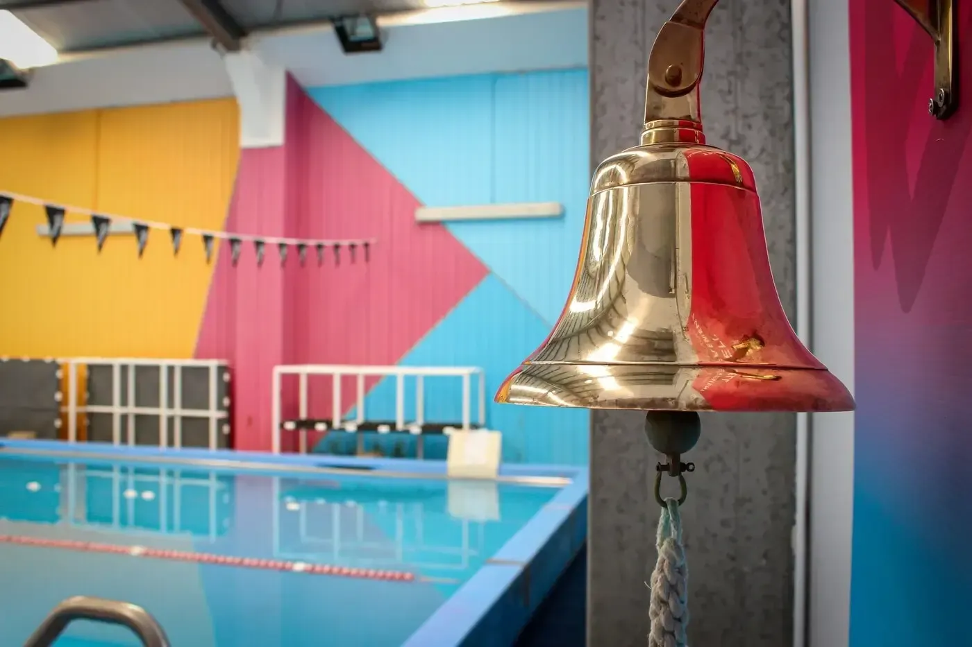 A pink float is sitting on top of a blue float in a pool.