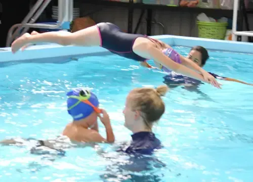 A woman is teaching a child how to swim in a pool.
