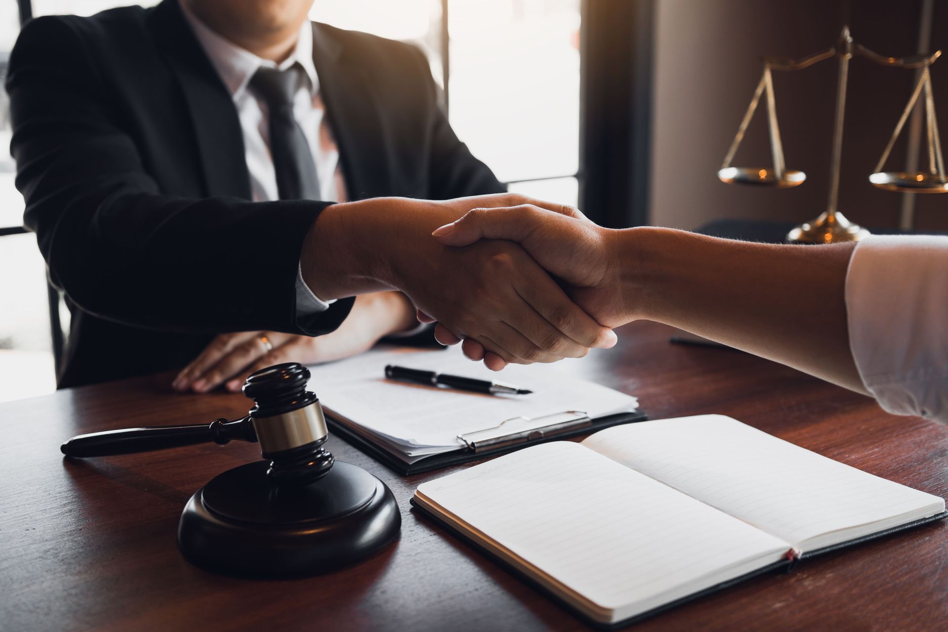 A man in a suit and tie is shaking hands with a woman.