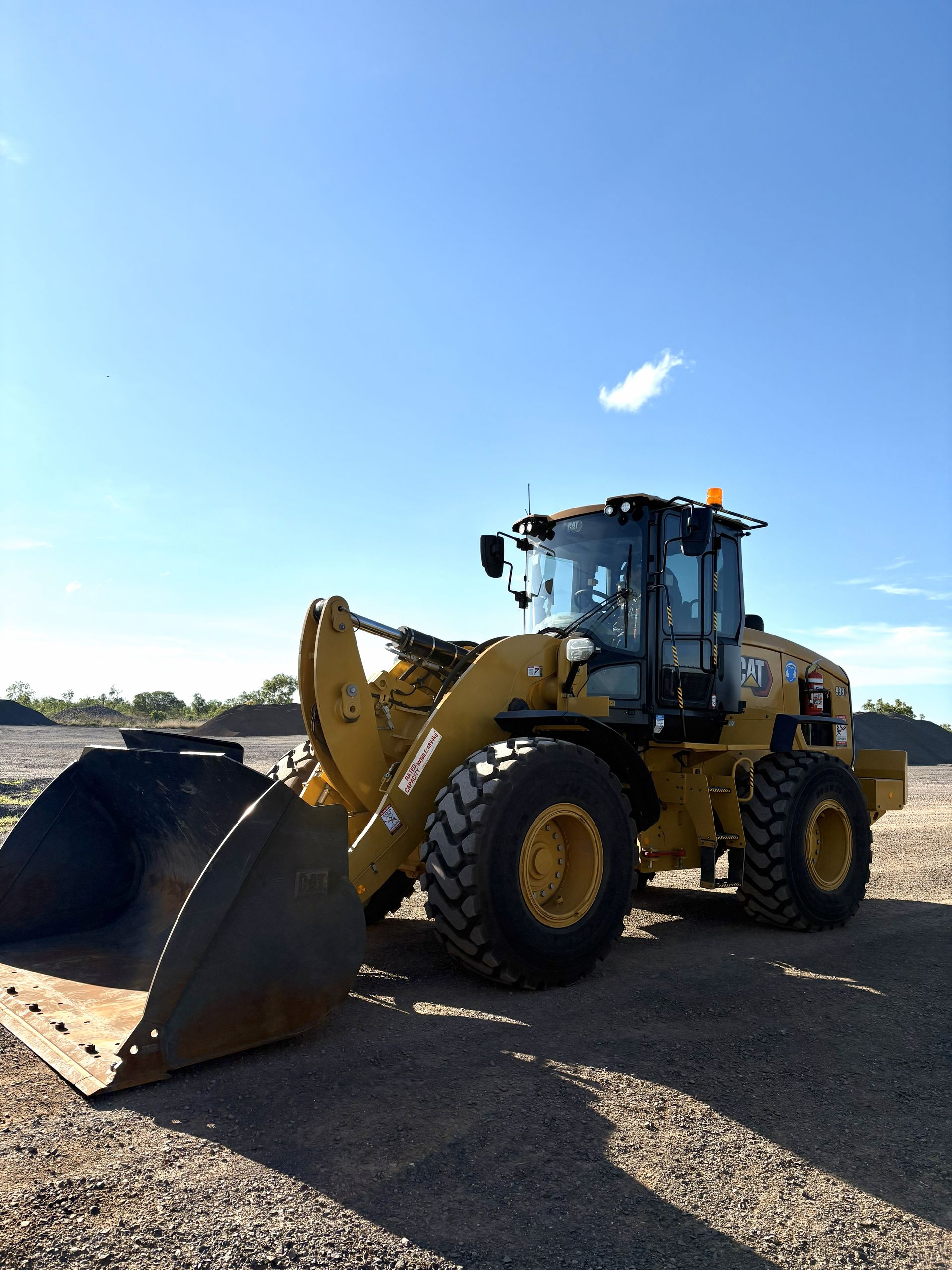 Yellow Caterpillar Wheel Loader Parked on Gravel Under a Blue Sky — D&S Quarries in Lansdowne, NT