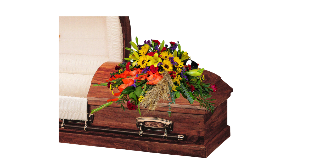 Wooden coffin adorned with a colorful floral arrangement beside a chair
