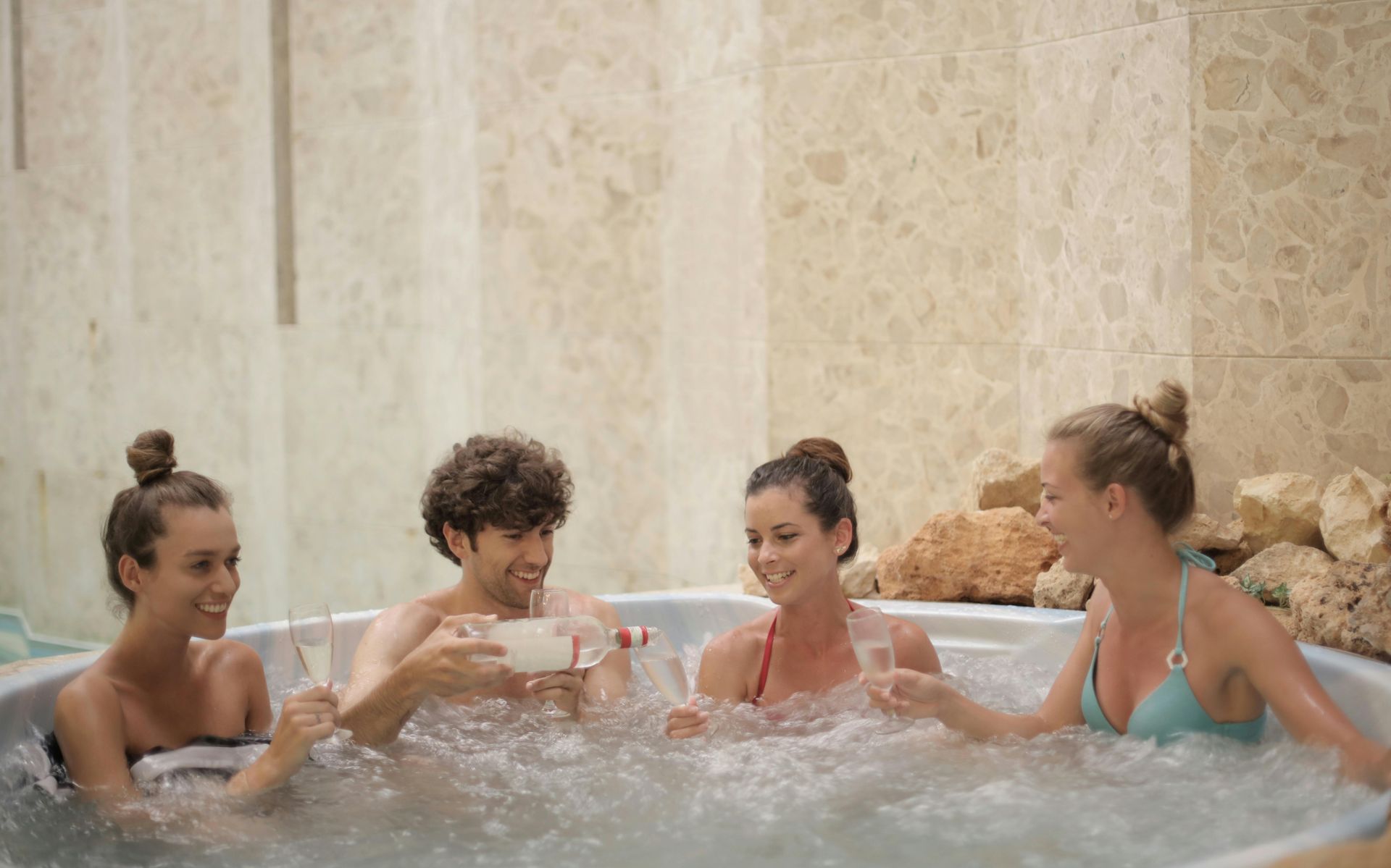 A group of friends enjoying a hot tub outside.