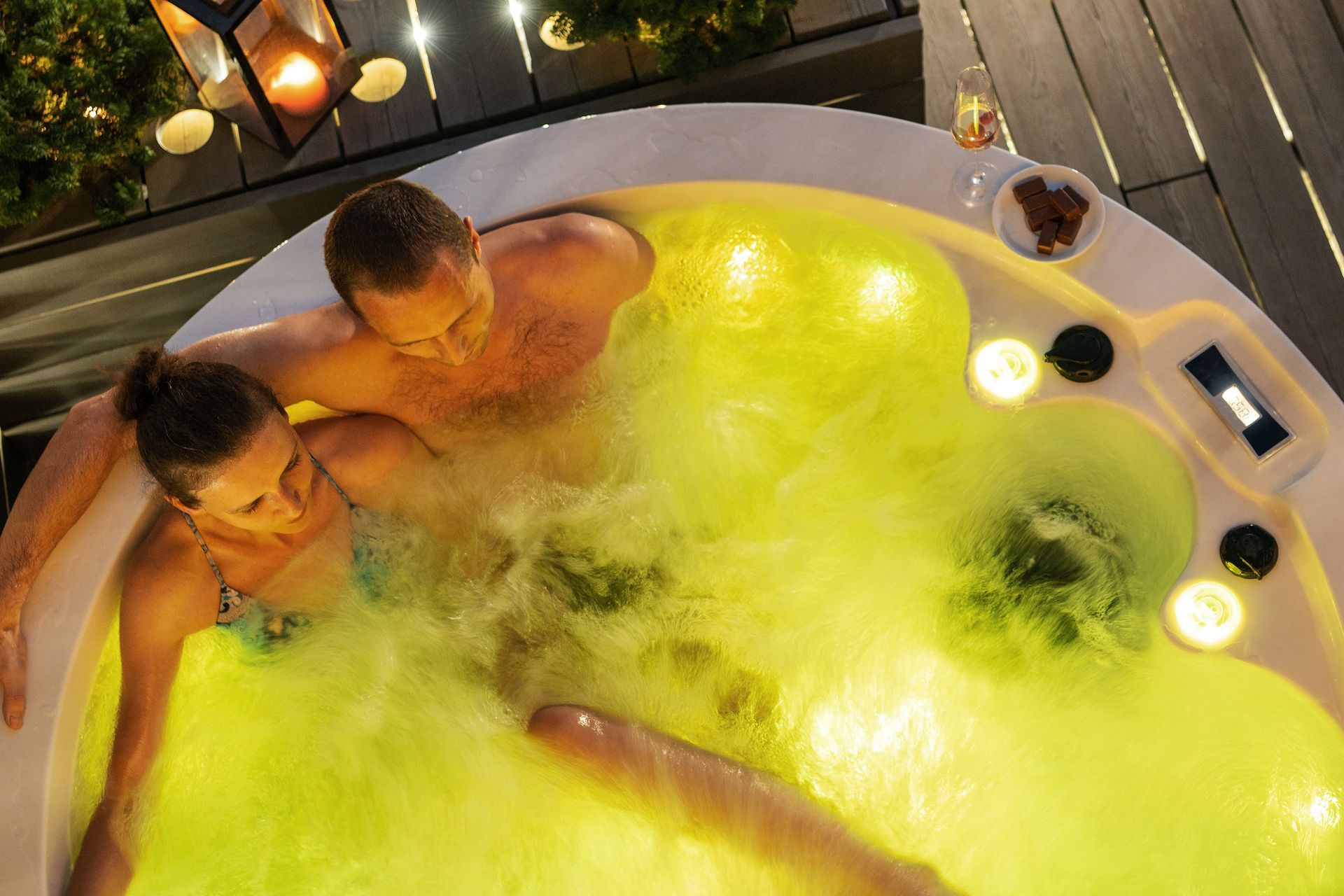 A man and a woman are sitting in a hot tub.