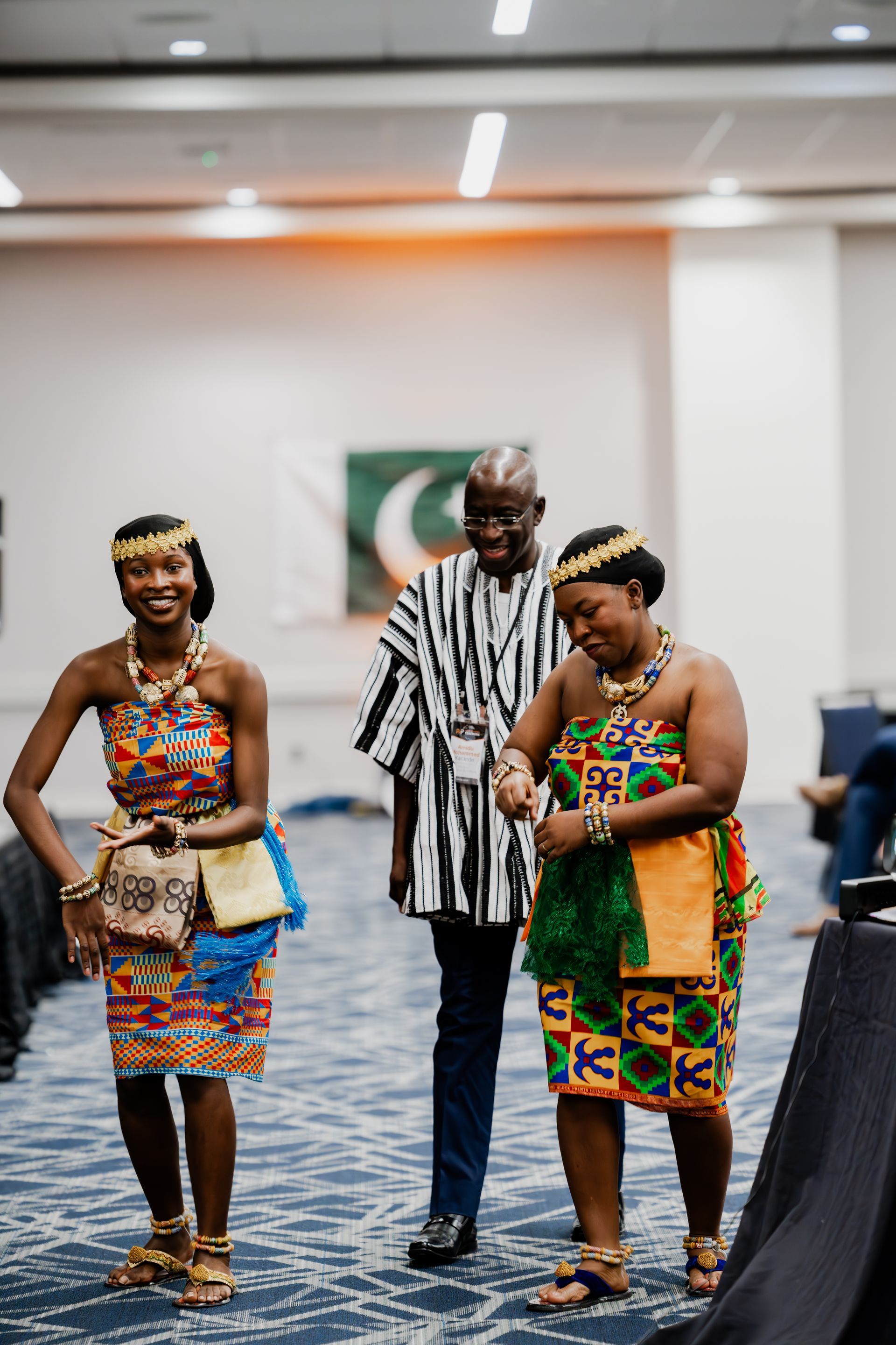 A man and two women are standing next to each other in a room.