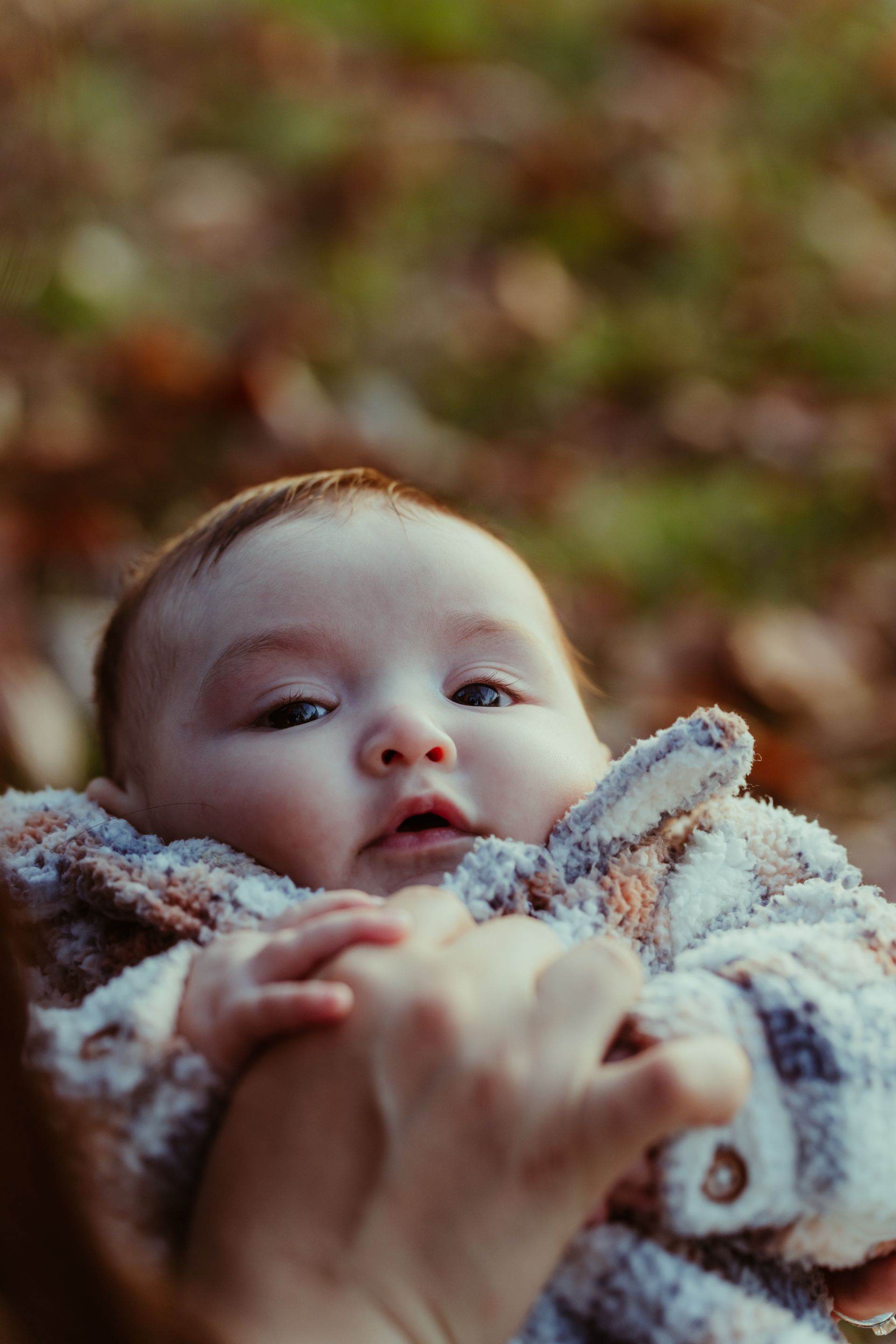 a close up of a person holding a baby in their arms .