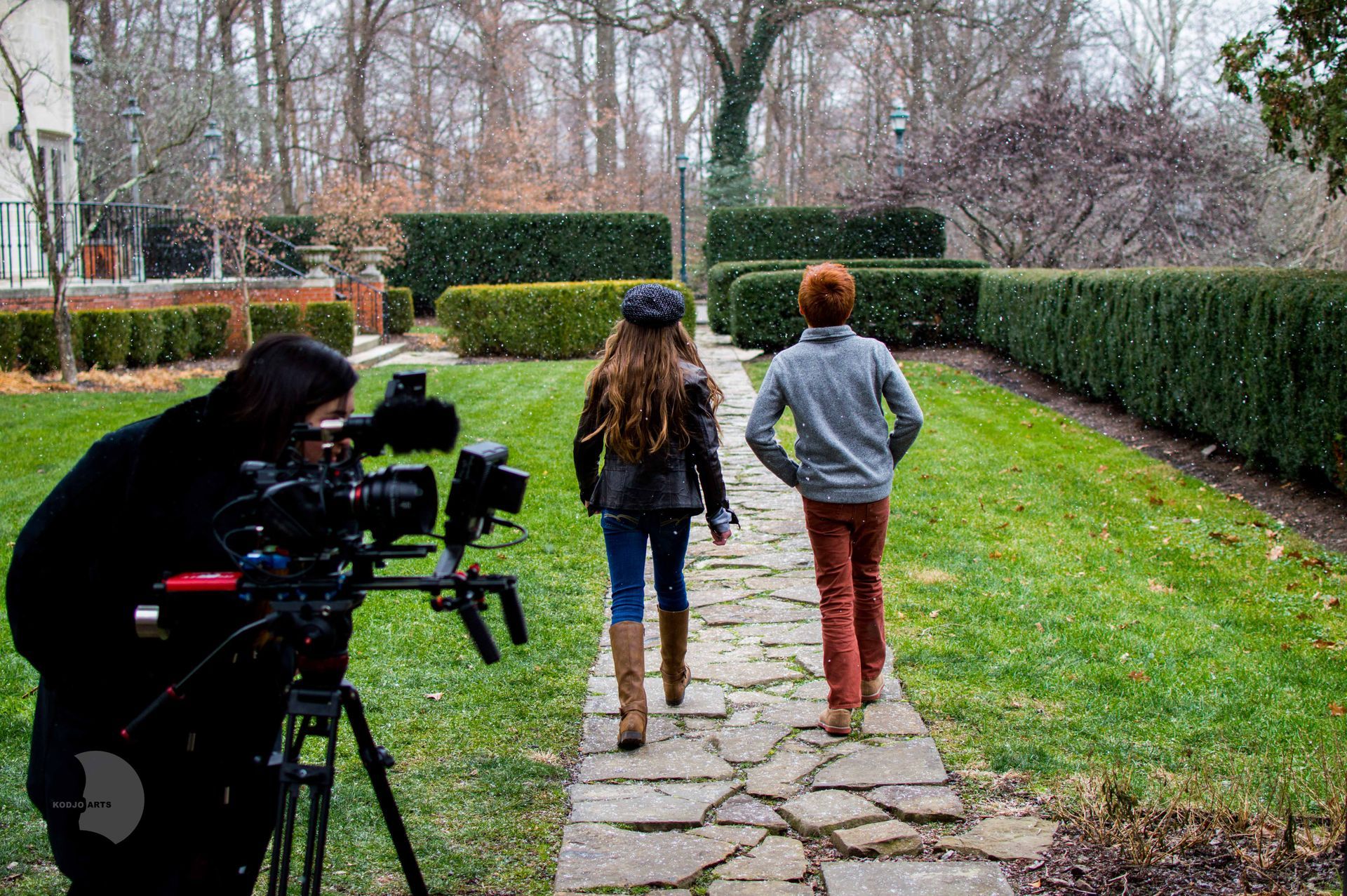a person is taking a picture of two people walking down a path .