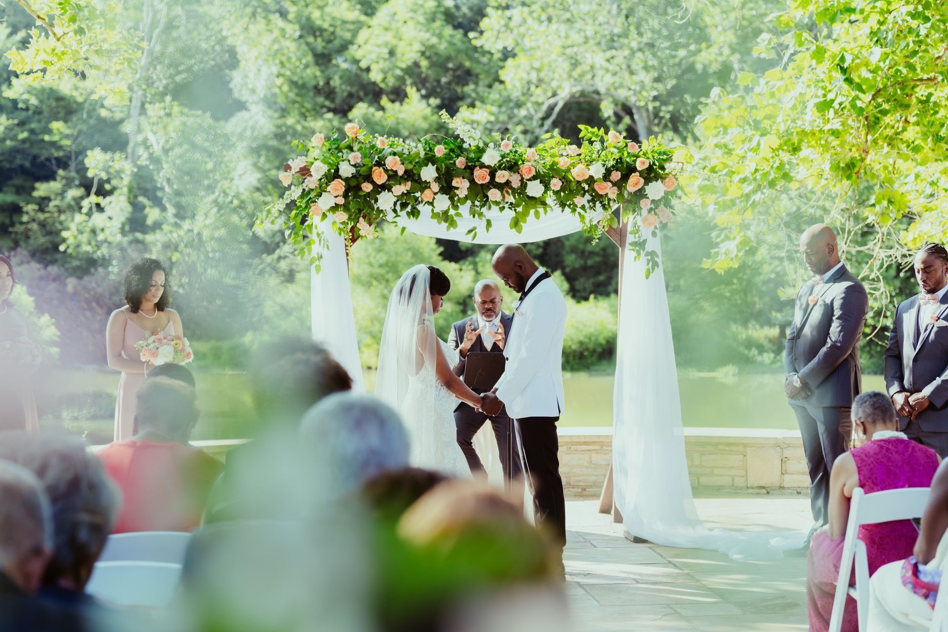 A bride and groom are holding hands during their wedding ceremony at darby house.
