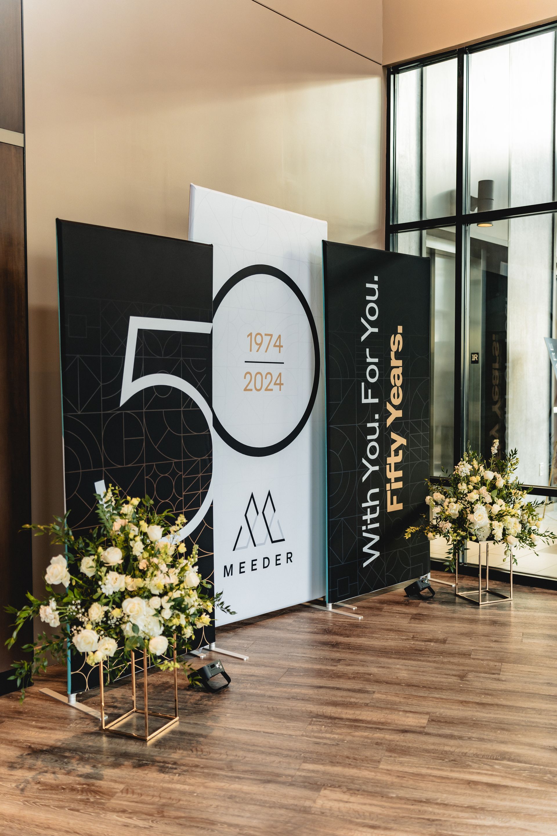 A room with a sign that says `` with you for fifty years '' and flowers in front of it.