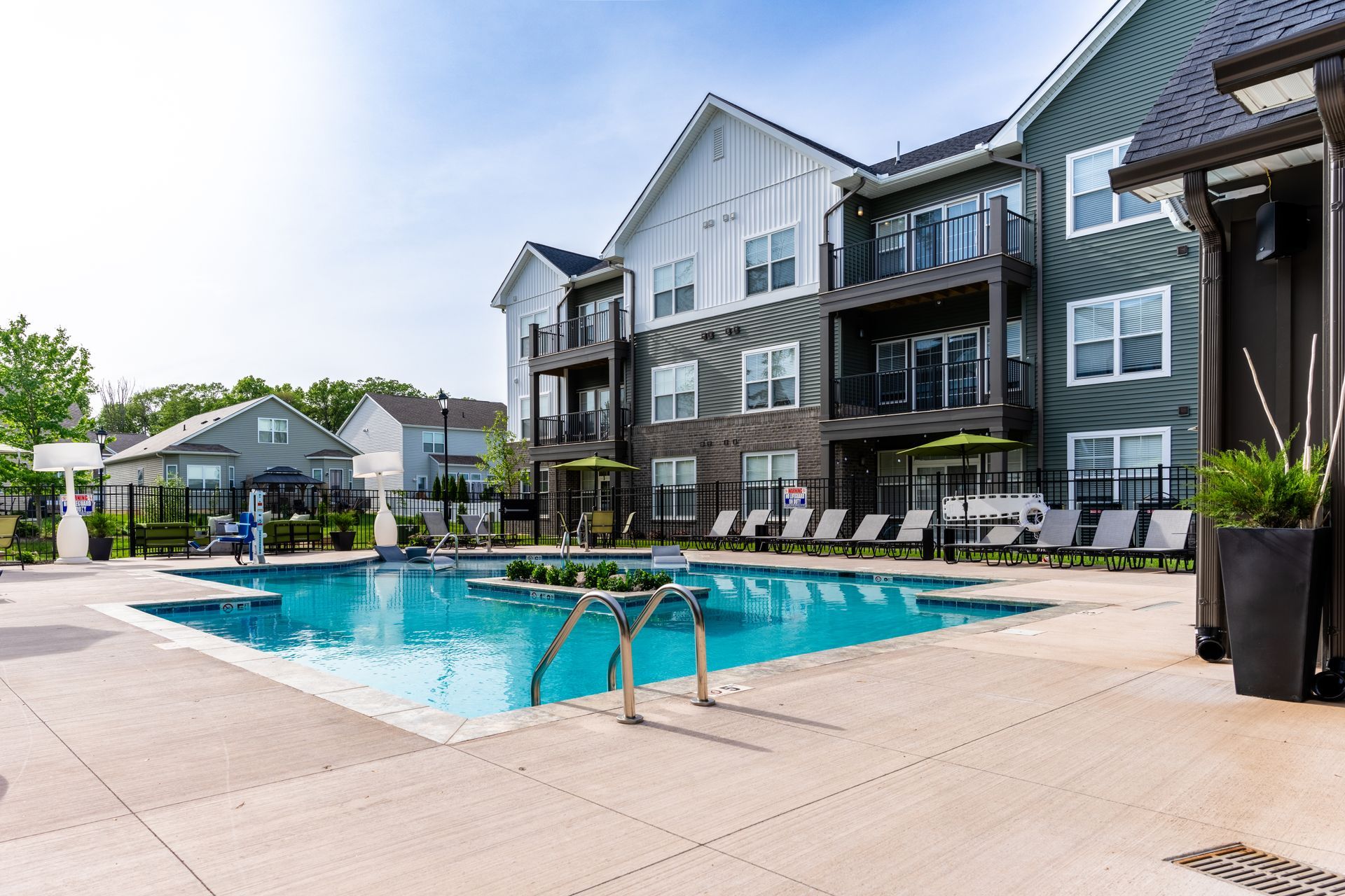 A large swimming pool in front of a large apartment building.