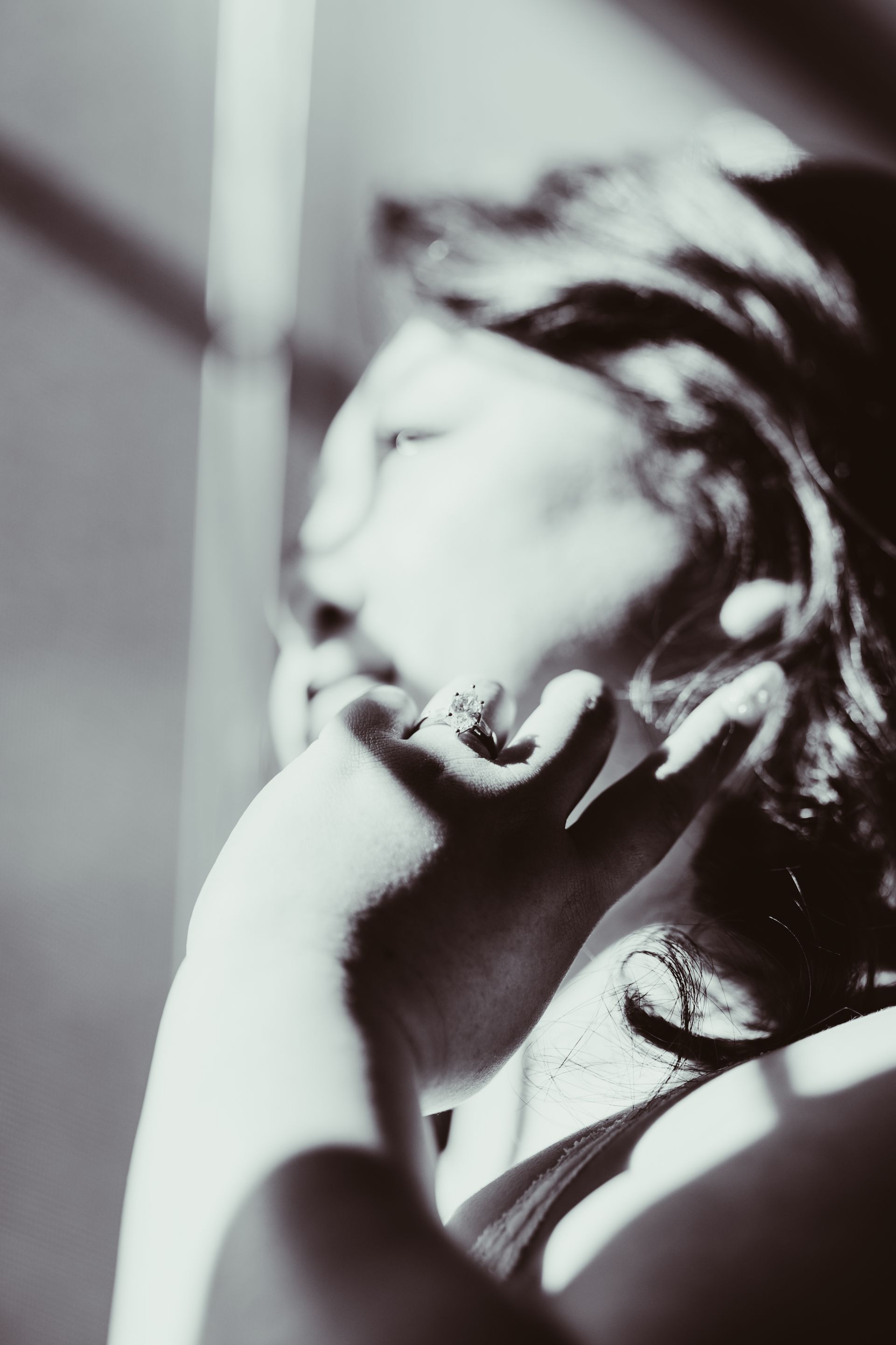 Woman in silhouette, resting chin on hand, looking off camera. Soft, natural lighting.