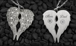 Two jeweled heart pendants on black pebbles, one labeled Mom and the other Dad.