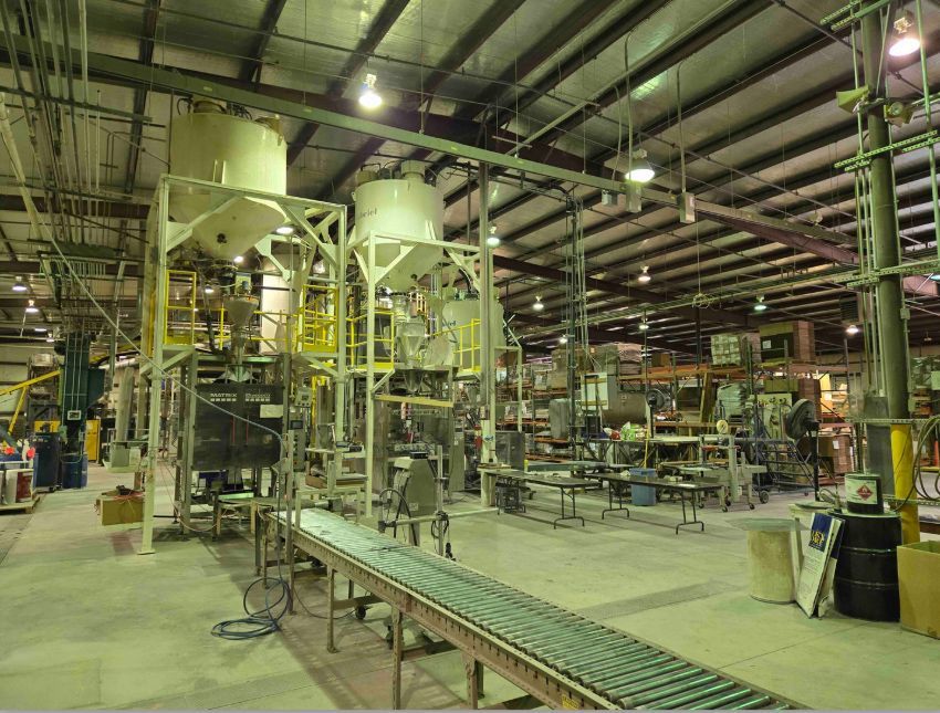 A large warehouse filled with lots of machinery and a conveyor belt.