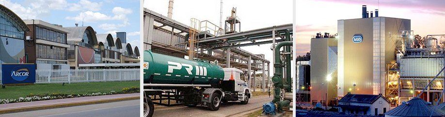 Tres naves industriales bajo un cielo nublado. Un camión cisterna está estacionado frente a una de ellas.